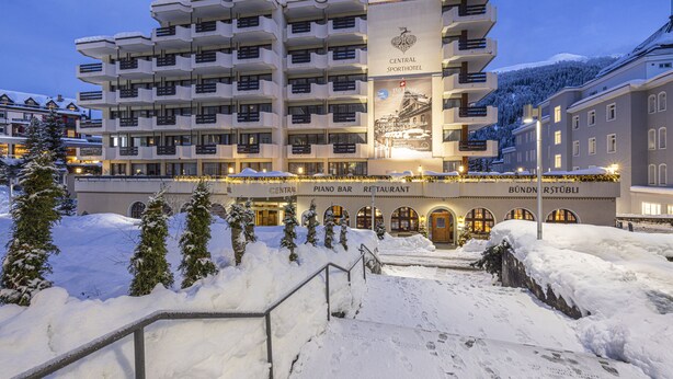 Un hotel de varios pisos con balcones, un bar de piano y un restaurante.
