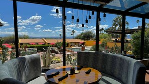 A seating area with a round table, cushioned chairs, and a view of a courtyard with cacti and umbrellas. - Westward Look Wyndham Grand Resort and Spa (Tucson)