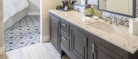 A bathroom with a sink, mirror, and dark cabinets.