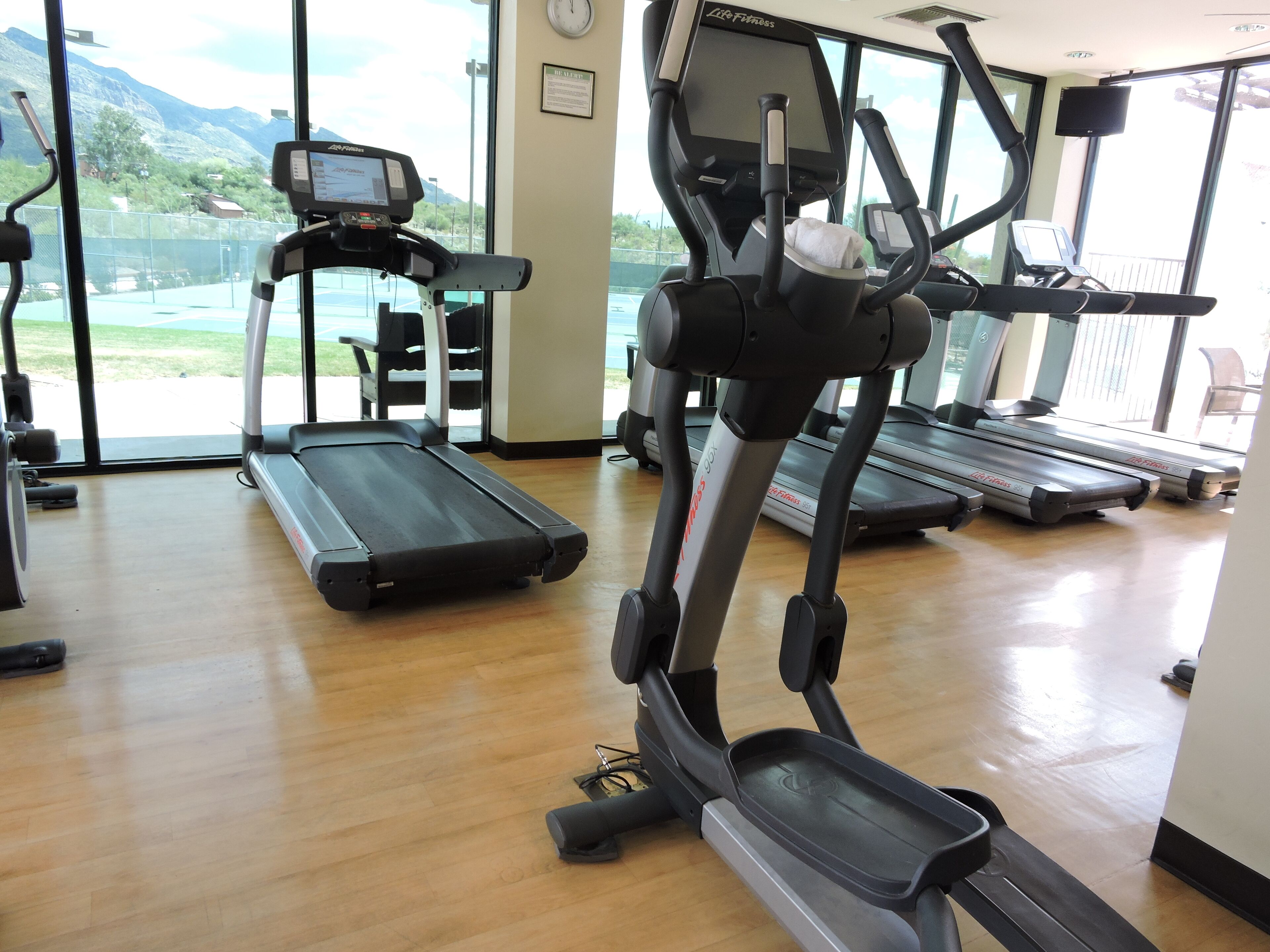 A gym with treadmills, an elliptical, and a stationary bike.