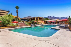 A pool area with lounge chairs, red umbrellas, and a mountain backdrop. - Westward Look Wyndham Grand Resort and Spa (Tucson)