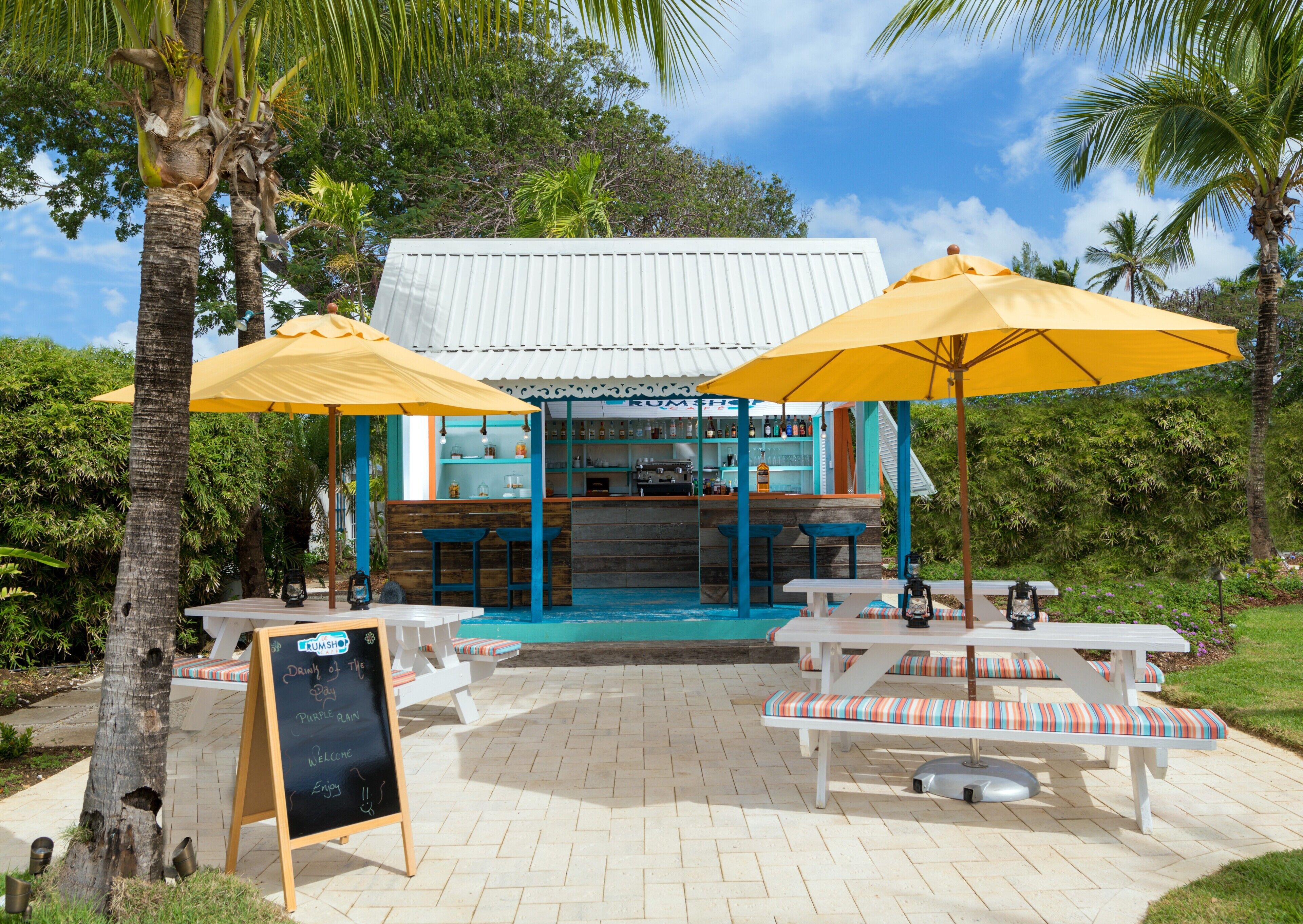 A restaurant with outdoor seating, a bar area, and a chalkboard sign.