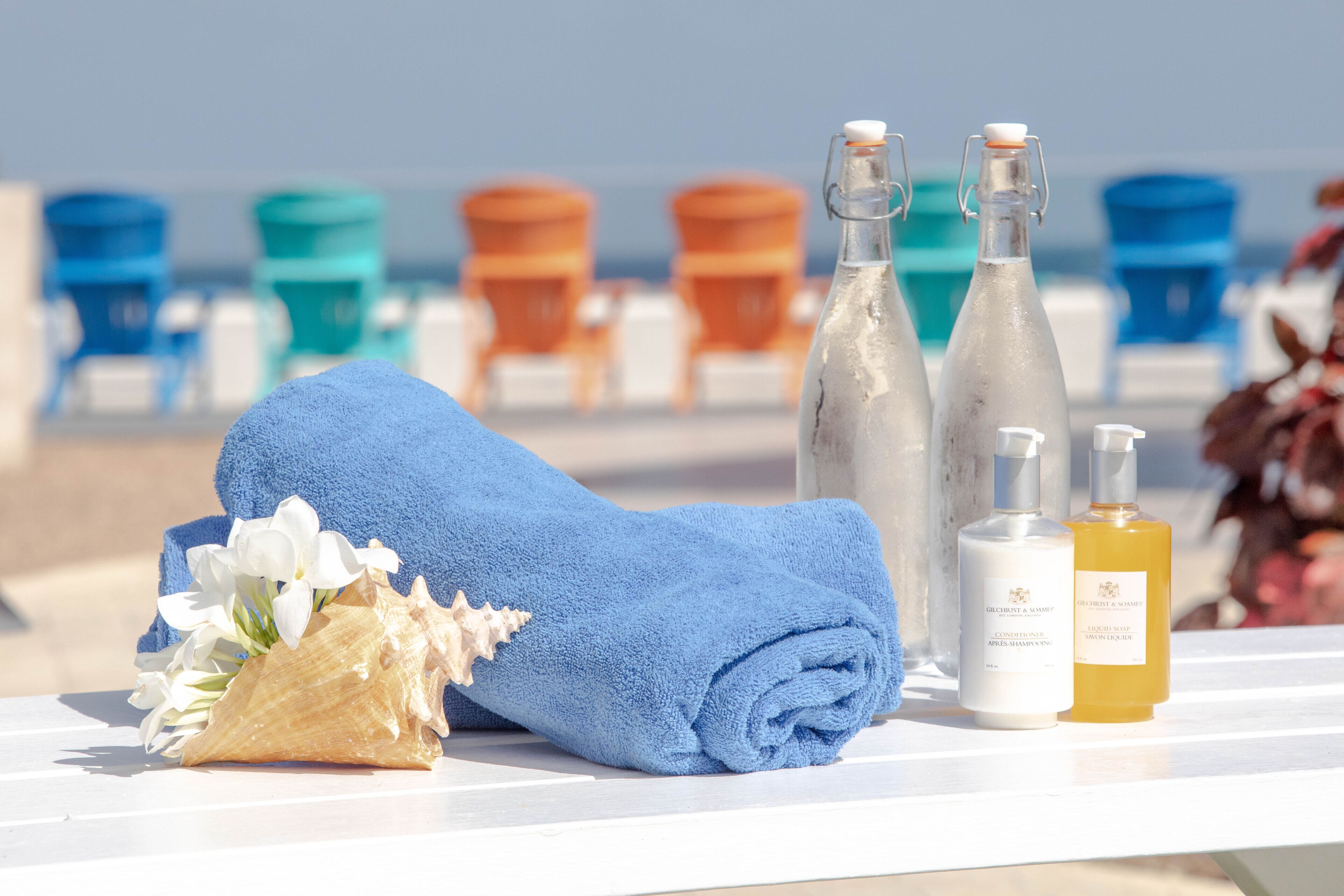 A beach setting with a towel, toiletries, and beach chairs.