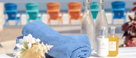 A beach setting with a towel, toiletries, and beach chairs.