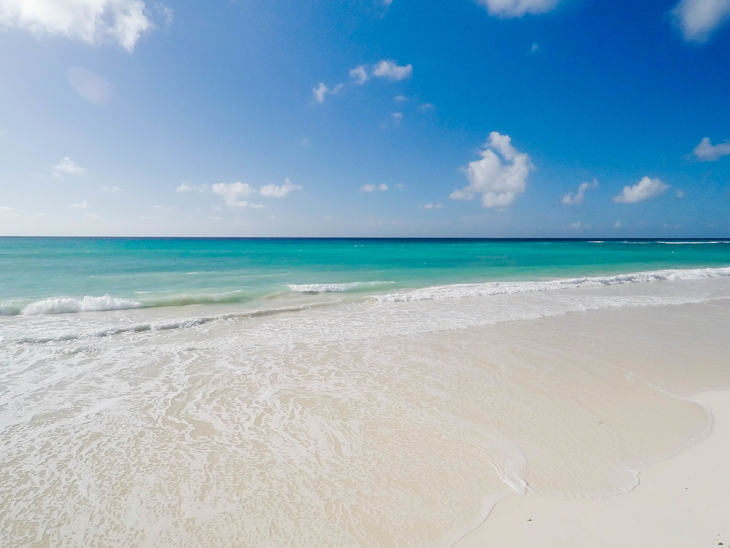 A beach with clear turquoise water and white sand.