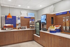 A breakfast area with a bakery section, a fruit display, and a juice dispenser. - Holiday Inn Express Exton by IHG (Exton)