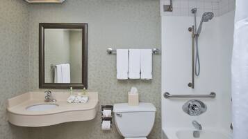 A bathroom with a sink, mirror, toilet, and shower.