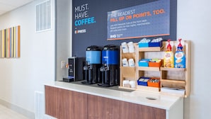A coffee station with branded dispensers, a sign promoting a rewards club, and a display of coffee products. - Holiday Inn Express Exton by IHG (Exton)