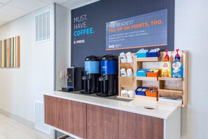 A coffee station with branded dispensers, a sign promoting a rewards club, and a display of coffee products. - Holiday Inn Express Exton by IHG (Exton)
