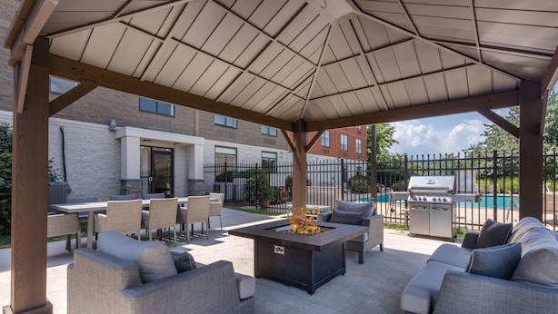 An outdoor patio with a fire pit, seating area, and barbecue grill. - Holiday Inn Express Exton by IHG (Exton)