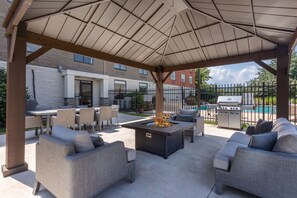 An outdoor patio with a fire pit, seating area, and barbecue grill. - Holiday Inn Express Exton by IHG (Exton)