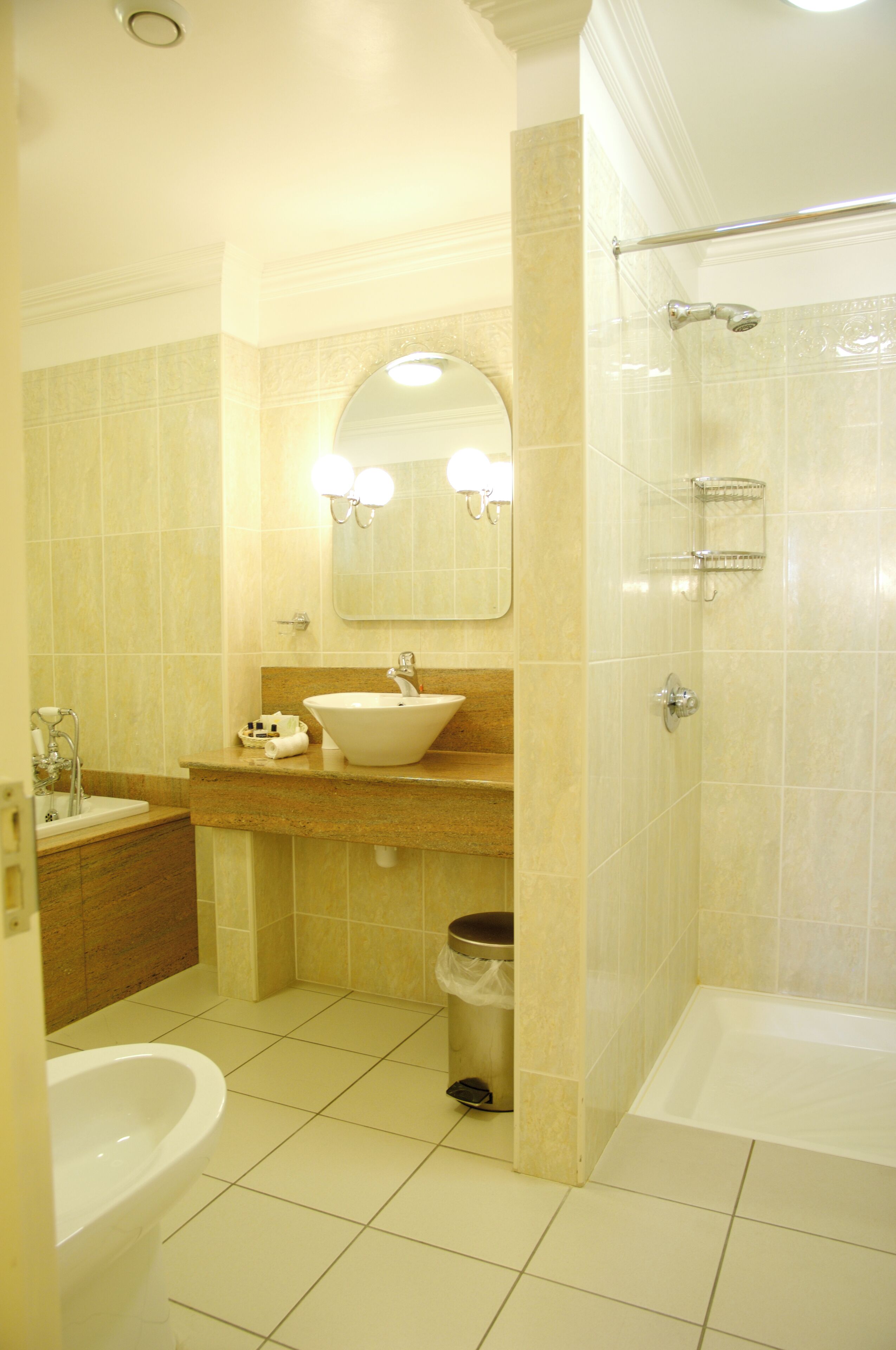 A bathroom with a sink, mirror, toilet, and bathtub.