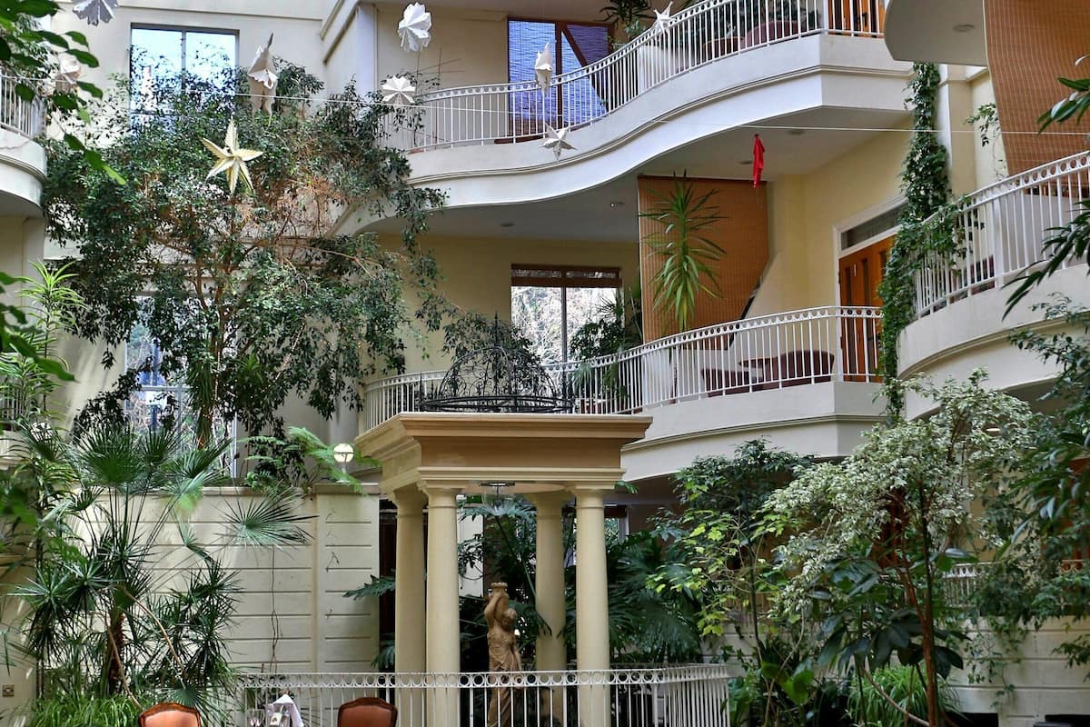 A multi-level atrium with balconies, indoor plants, and seating areas.