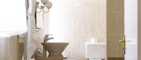 Un baño moderno con ducha, lavamanos, inodoro y bañera.