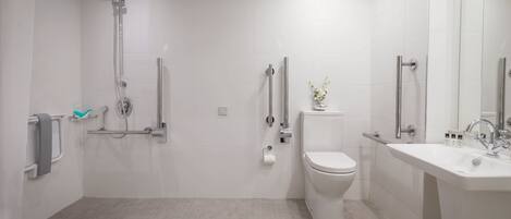 A modern bathroom with a shower, toilet, and sink.