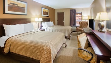 A hotel room with two beds, a desk, a chair, and a TV.