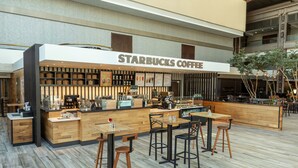 A Starbucks coffee shop with a modern design, featuring wooden furniture and a spacious layout. - Hyatt Regency Buffalo / Hotel and Conference Center (Buffalo)