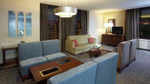 A hotel room with a sofa set, a small coffee table, a TV, and a lamp. - Hyatt Regency Buffalo / Hotel and Conference Center (Buffalo)