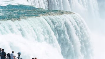 Una cascada imponente con una plataforma de observación y gente contemplándola.