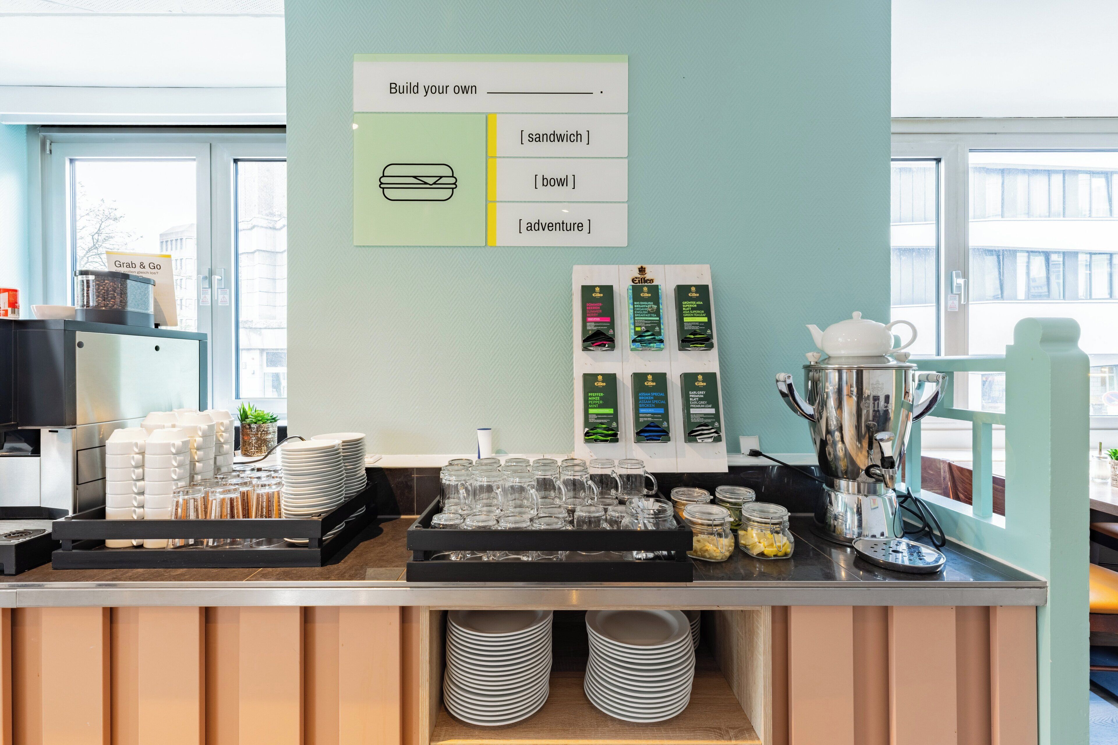 A breakfast bar with a sign indicating options to build a sandwich, bowl, or adventure.