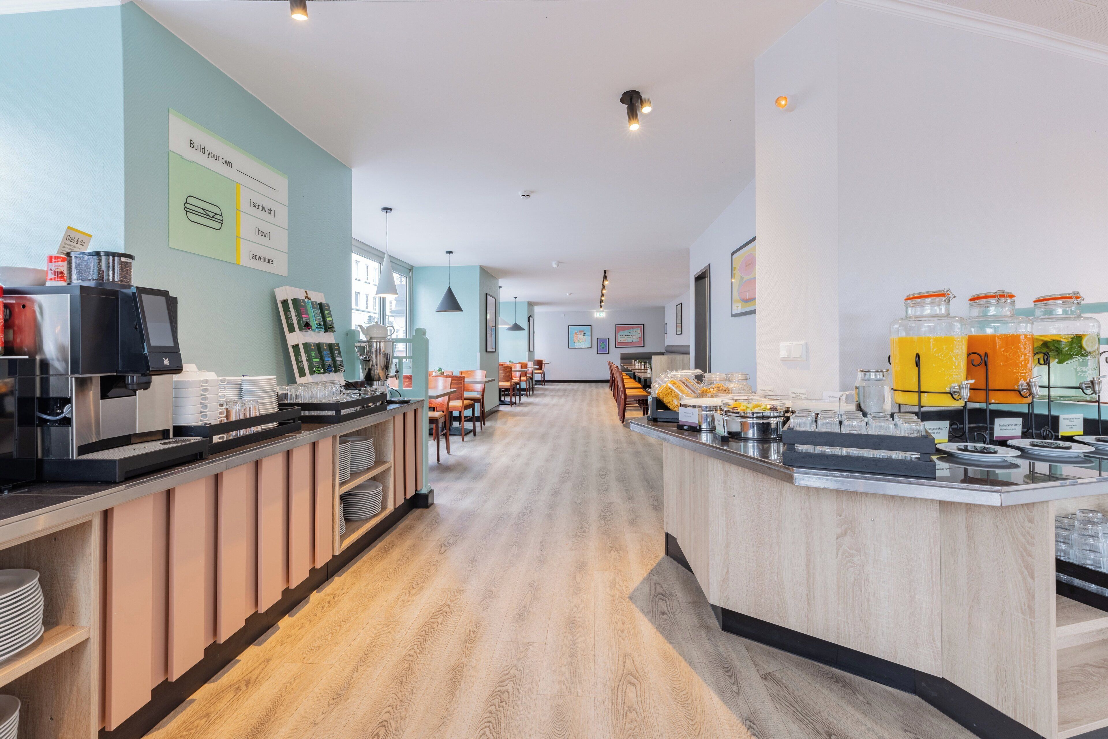 A modern cafe with a wooden counter, seating area, and various food and drink dispensers.