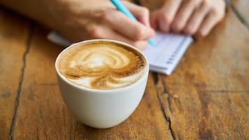 A cup of coffee with latte art on a wooden table.