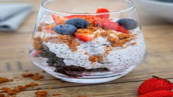 A dessert in a glass on a wooden surface.