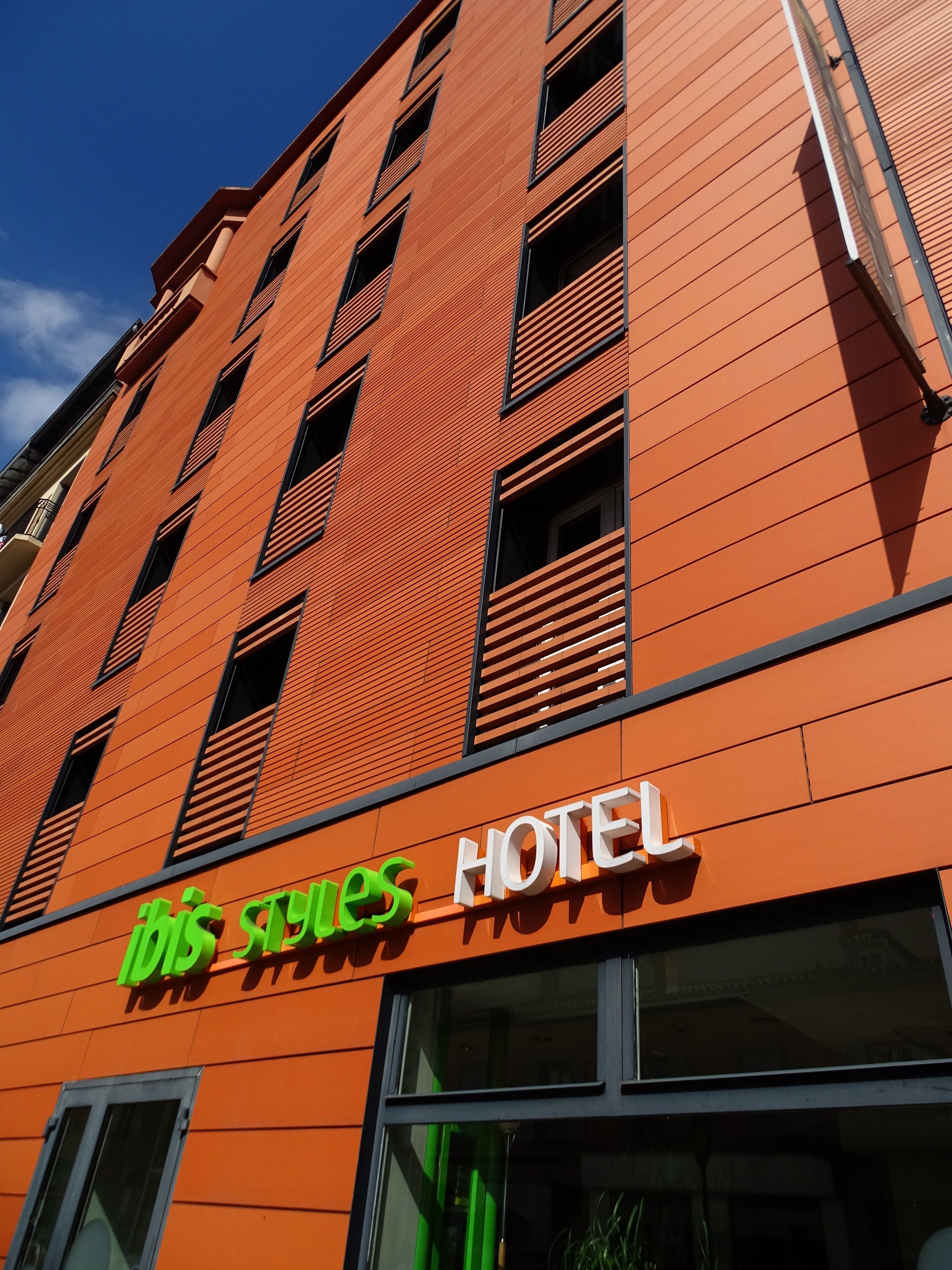 Un edificio moderno di un hotel con facciata rossa e numerose finestre.
