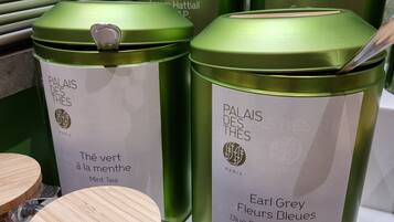 Green containers labeled 'Palais des Thés' with 'The vert à la menthe Mint Tea' and 'Earl Grey Flowers Earl Grey Blue Flowers'.