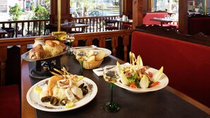 Un restaurant donnant sur la rue, avec des meubles en bois et une variété de plats servis à table.