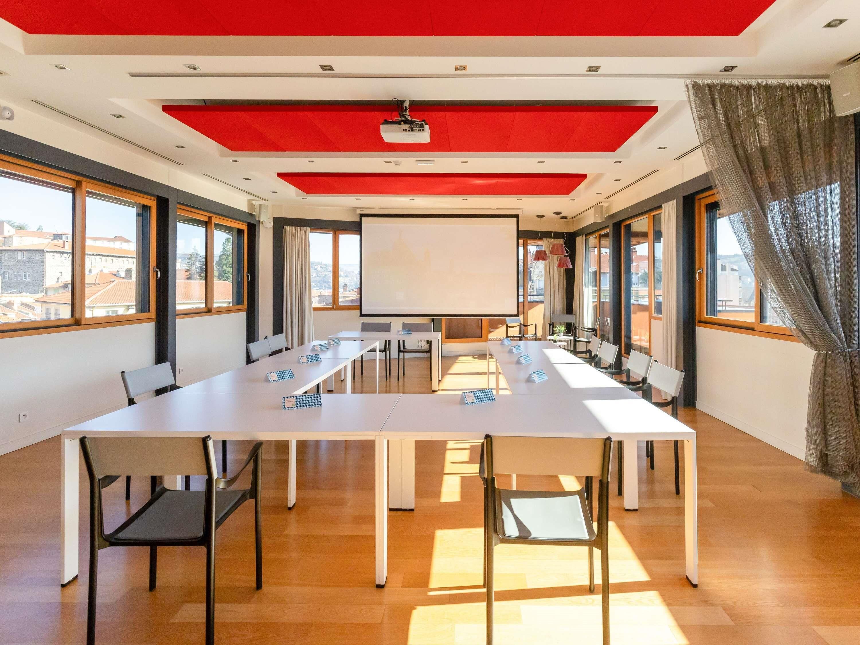 A conference room with a long table, chairs, a projector, and a whiteboard.