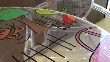 A transparent plastic bag with colorful drawings of a house, a tree, a sun, and a candy.