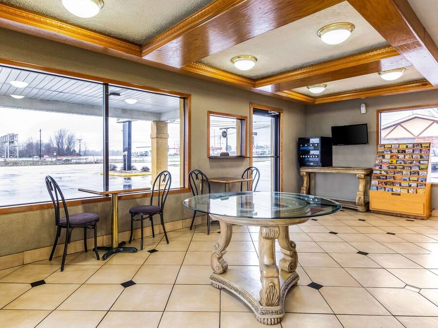 A restaurant interior with a glass-top table, chairs, a TV, and a display of cards.