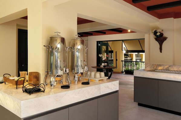 A kitchen area with stainless steel appliances, a marble countertop, and a view of the dining area. - Hotel El Convento (San Juan)