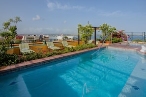 Una piscina al aire libre, tumbonas