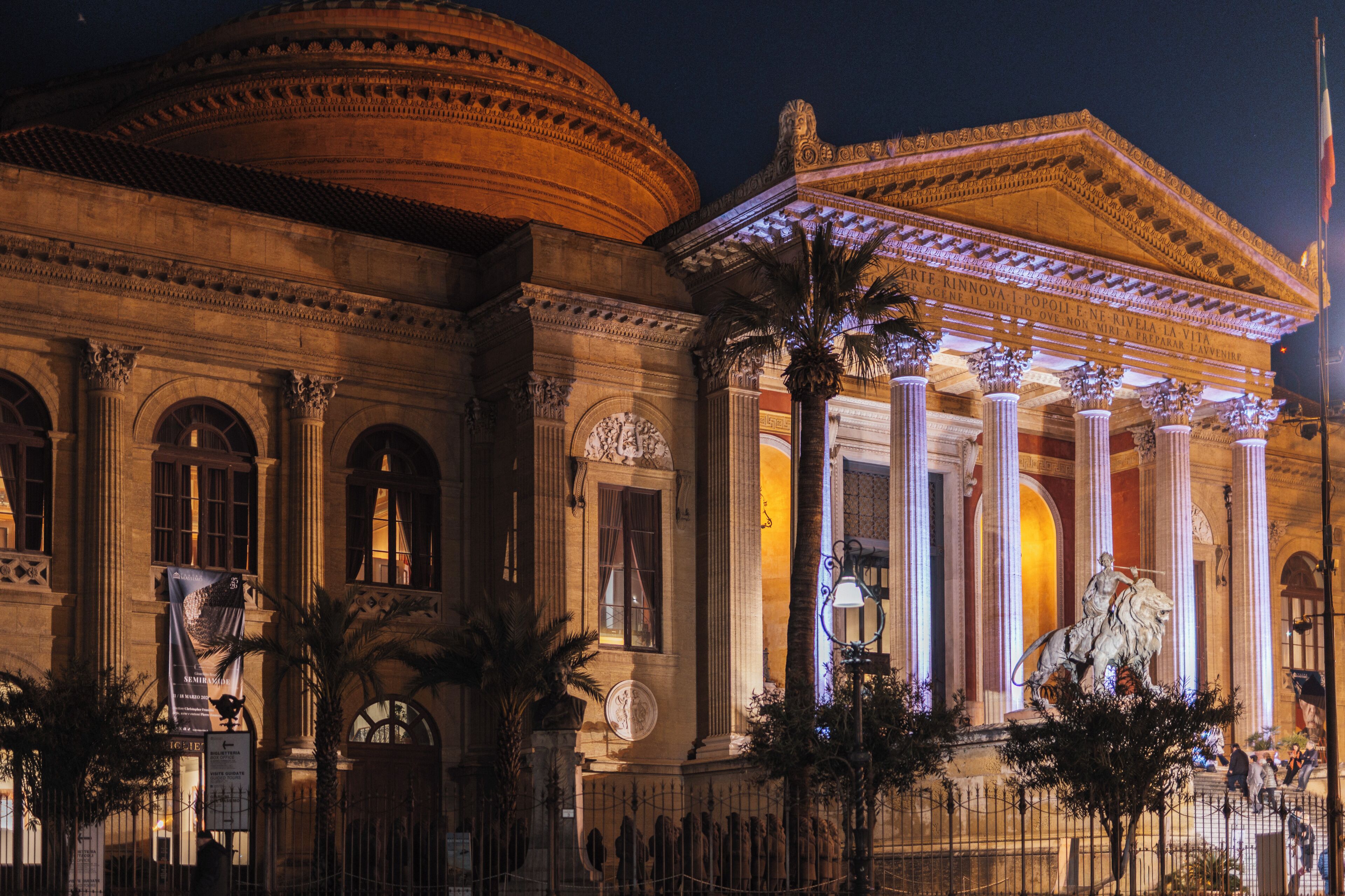 A classical building with columns, a statue, and a dome.