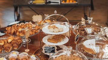 A buffet with various pastries and desserts displayed on glass stands.