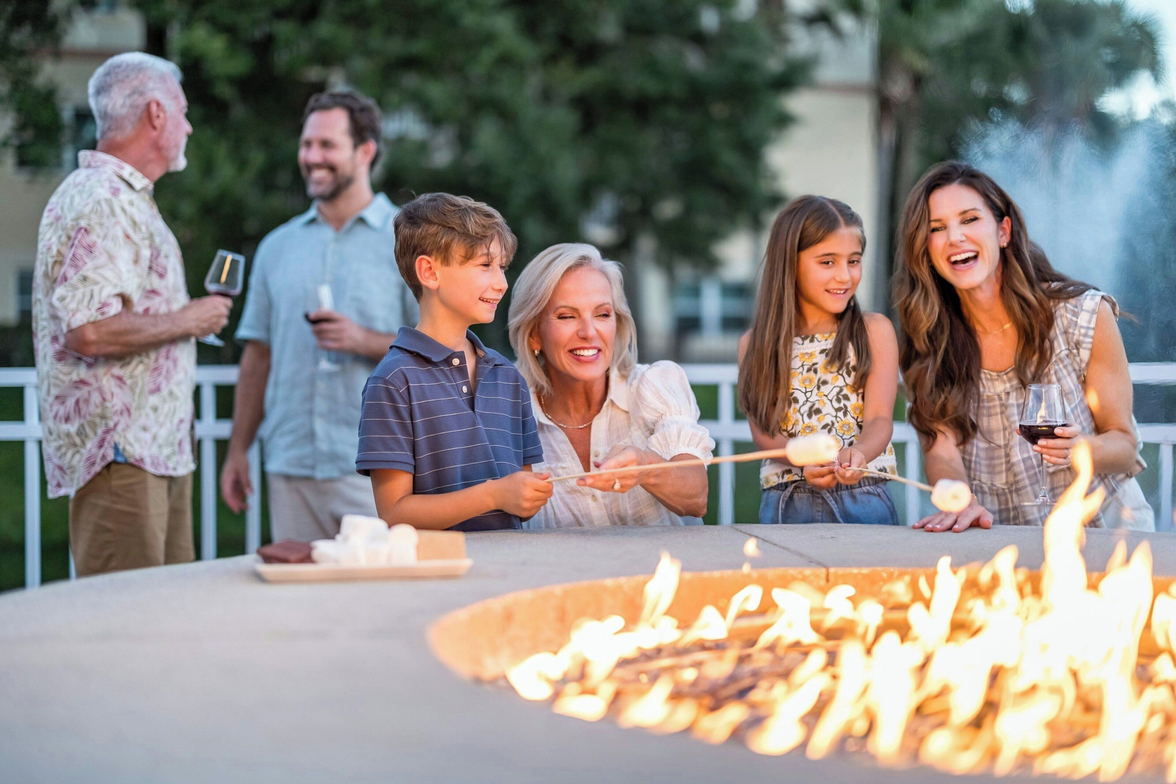 A group of people gathered around a fire pit outdoors.