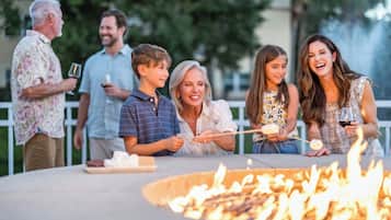 A group of people gathered around a fire pit outdoors.