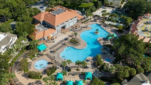 Vue aérienne d’un complexe hôtelier doté de plusieurs piscines, de palmiers et d’espaces de détente.