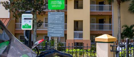 A parking sign for electric vehicles and a Park & Plug sign with a QR code.