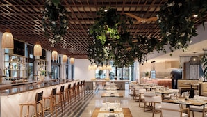 A modern restaurant with a bar area, wooden ceiling, and hanging plants. - Hilton Fort Lauderdale Marina (Fort Lauderdale)