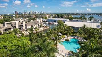 Un resort con piscina, palmeras y un puerto deportivo.