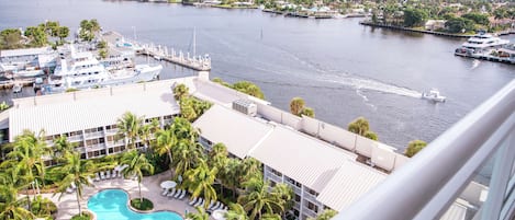 A hotel with a pool, waterfront view, and docked boats.