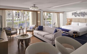 A hotel room with a bed, a sofa, a chair, a small table, and a balcony with outdoor furniture. - Hilton Fort Lauderdale Marina (Fort Lauderdale)