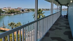 Un balcón con vista a un puerto deportivo y al paisaje urbano.