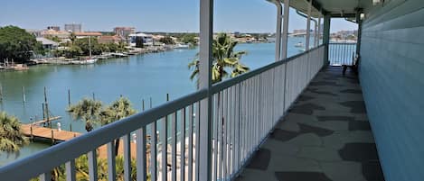 Un balcón con vista a un puerto deportivo y al paisaje urbano.