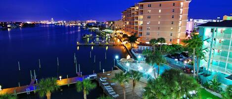 A waterfront hotel with multiple balconies, a dock, and a pool area.