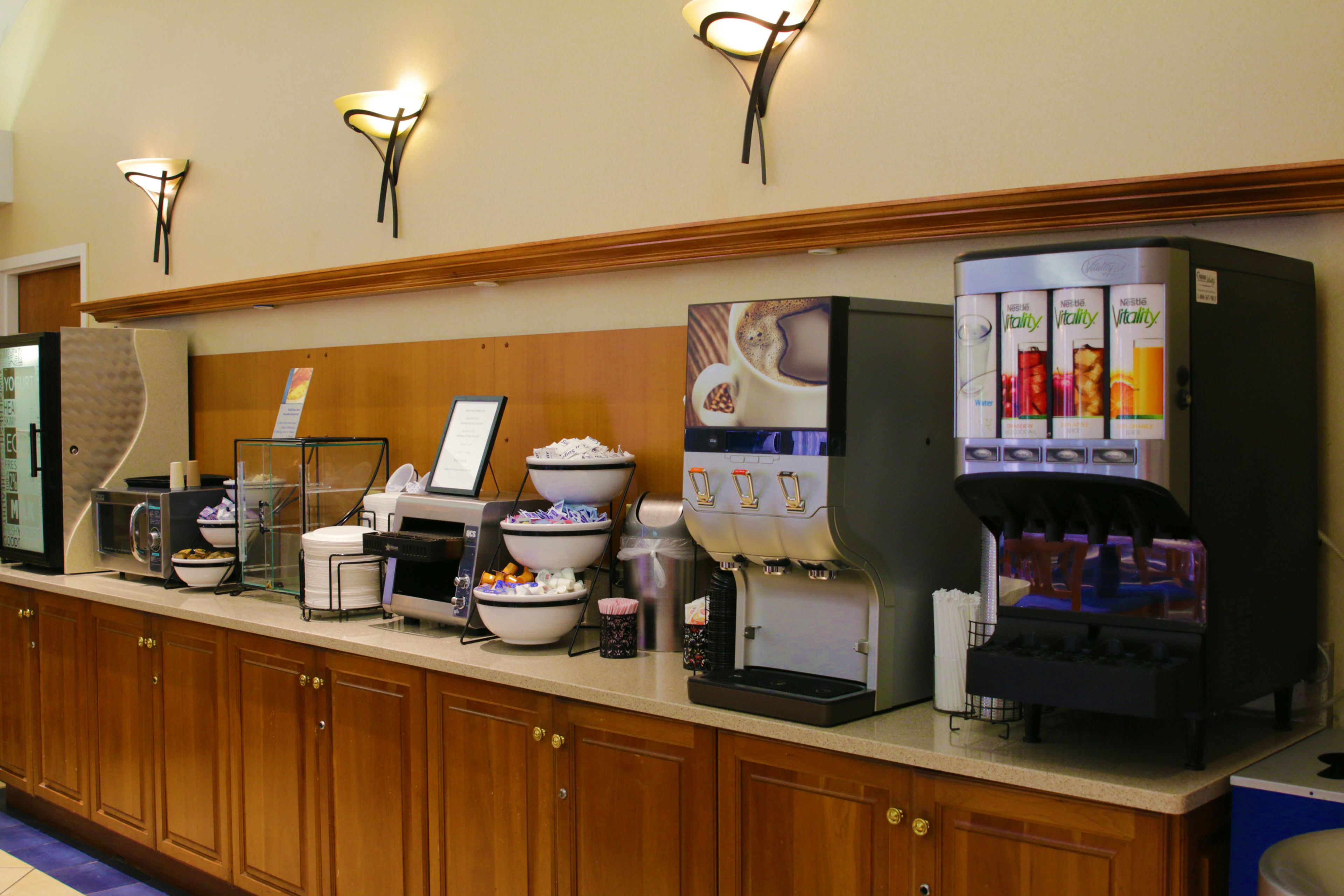 A buffet counter with various food and drink dispensers, including a coffee machine and a beverage dispenser.