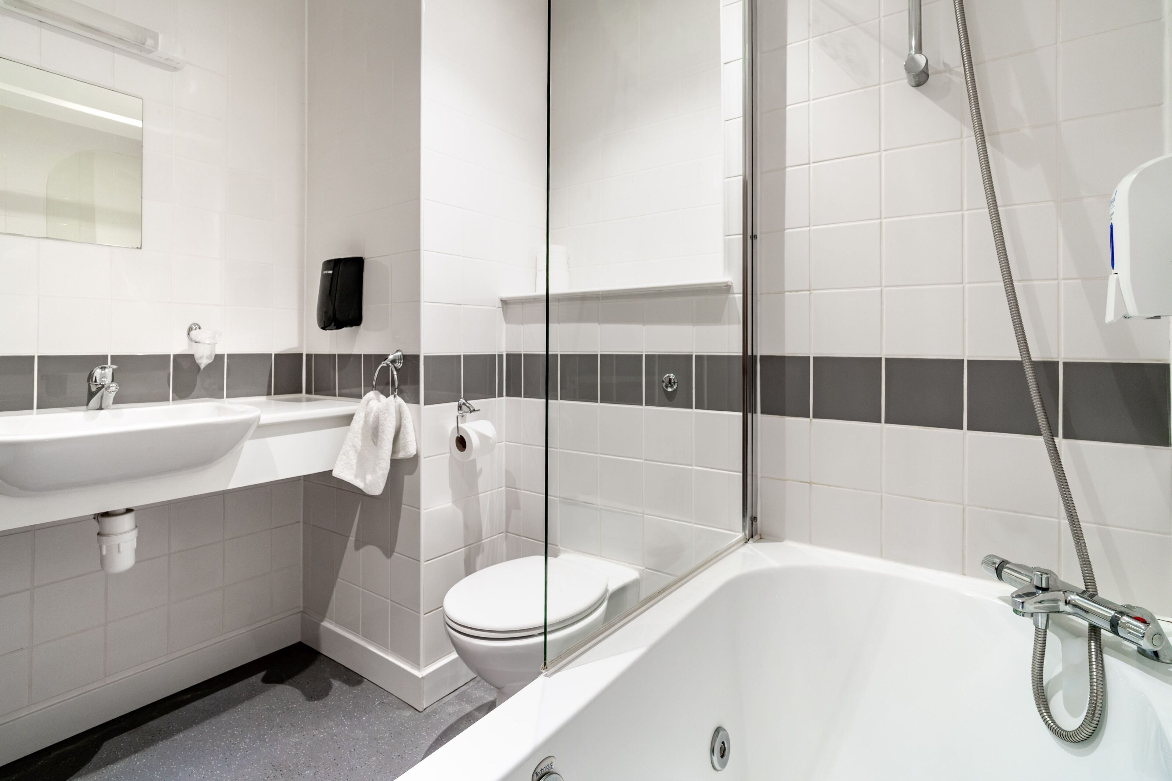 A modern bathroom with a white sink, toilet, and bathtub.